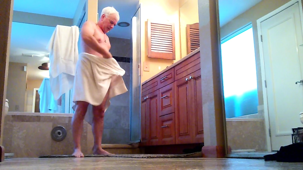 Старый мужчина принимает душ